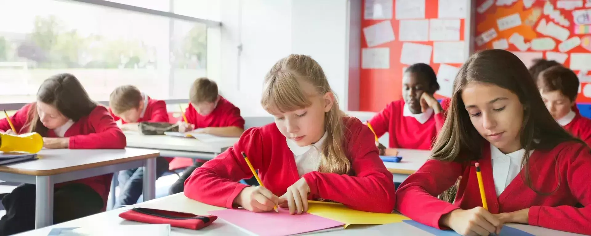 Students writing in classroom 170126262 1920x768