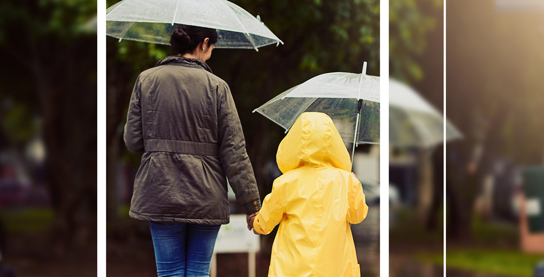 Mother and child walking in the rain with umbrellas