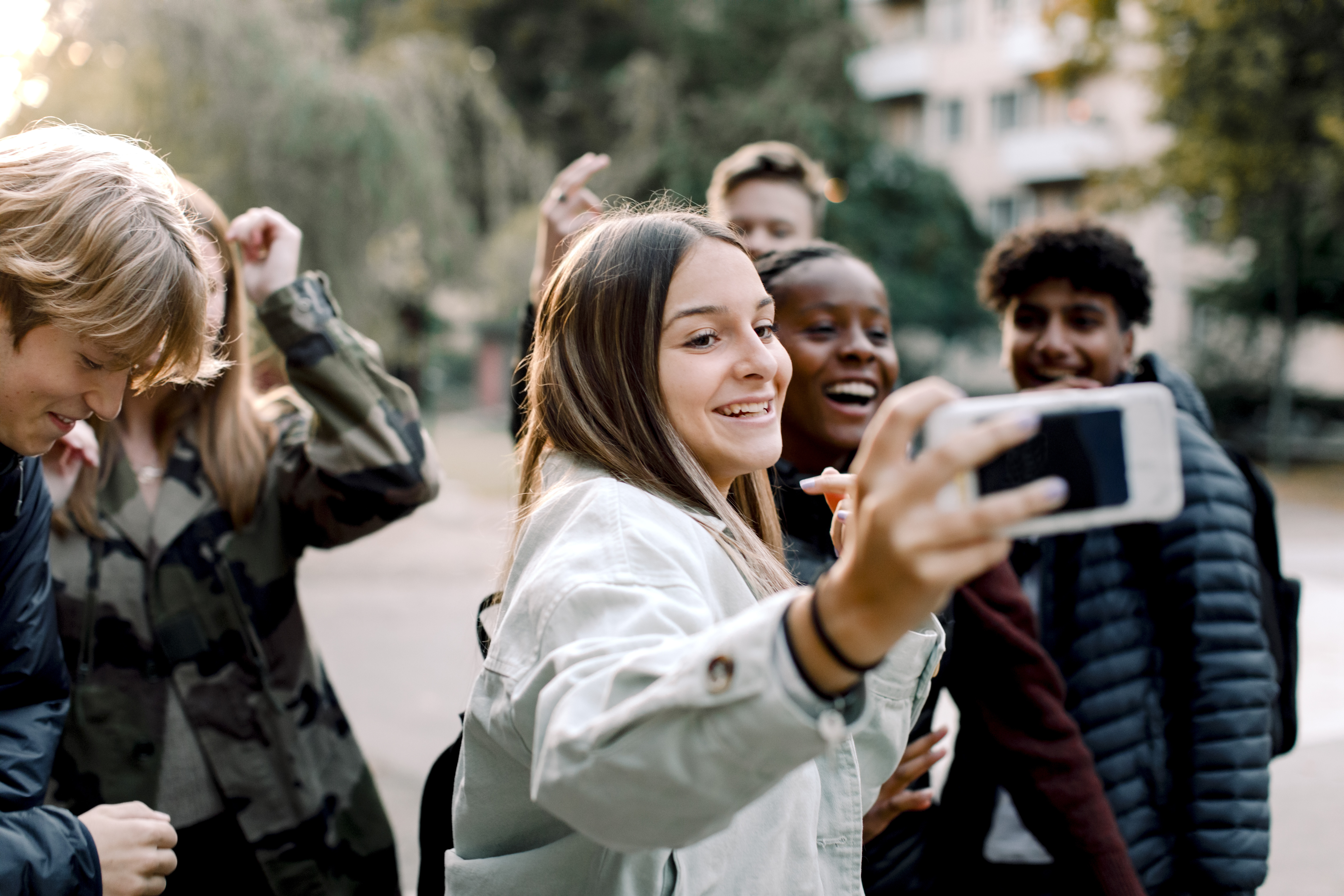 Young people looking happy with phone GettyImages-1241442931.jpg