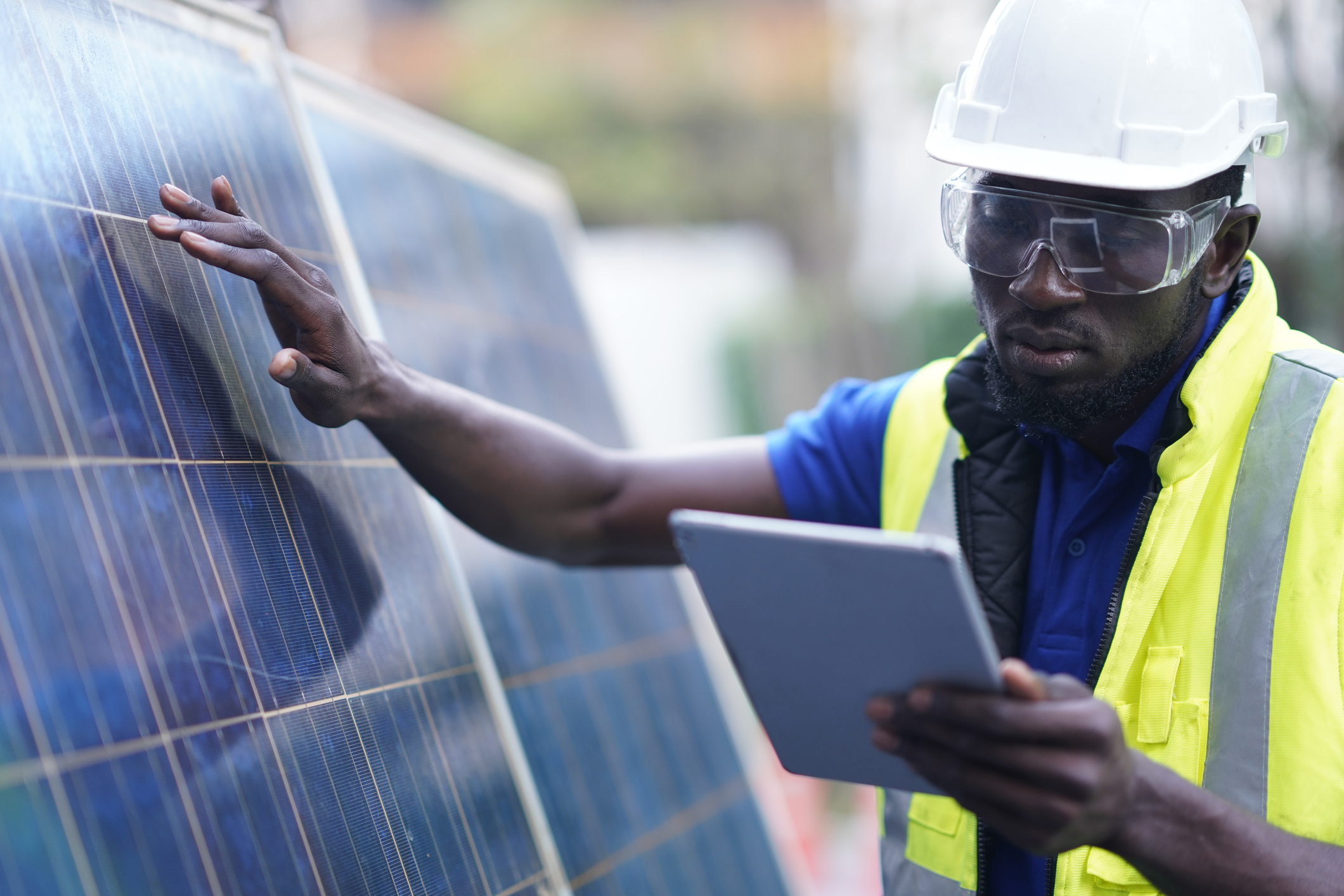 Capita Climate Change Hub Man looking at tablet while touching a solar panel