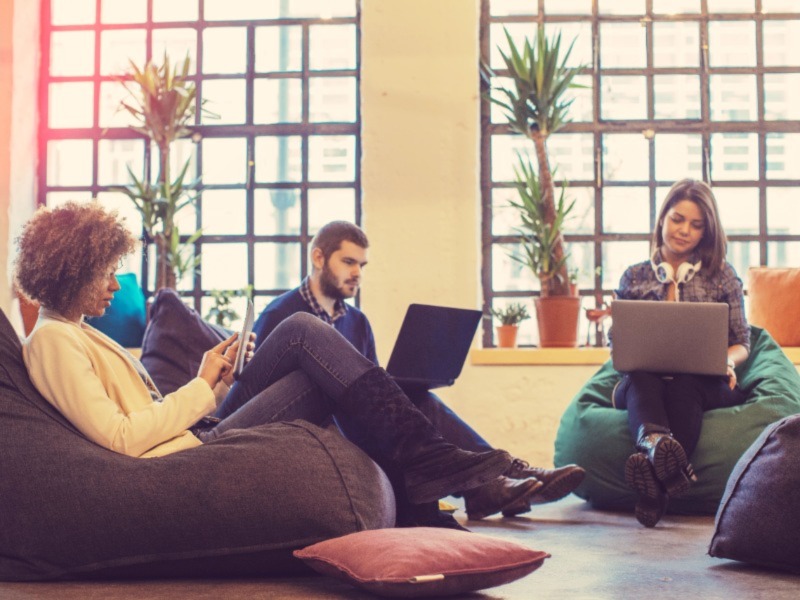 young people sitting and using laptop