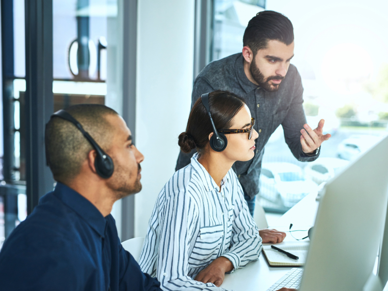 Businessman assisting his colleagues in a call centre