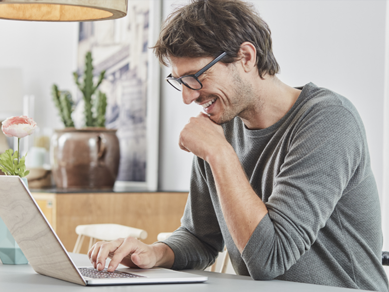 men smiling and using laptop