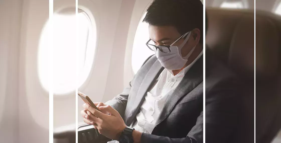 The person is using mobile in the plane