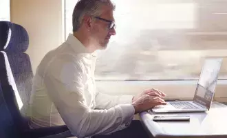 Man using train on laptop