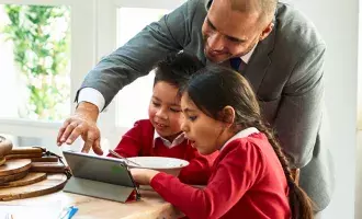 Parent looking at tablet with children