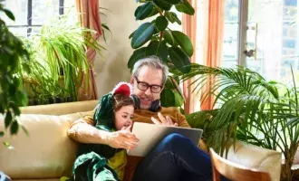 Grandfather playing game on laptop with granddaughter - 800x600 GettyImages-1166771651