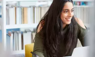 Woman working on computer in library