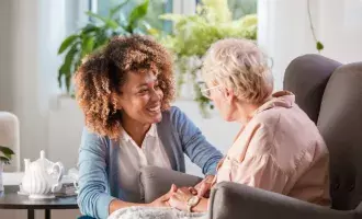 Friendly nurse supporting an eldery lady