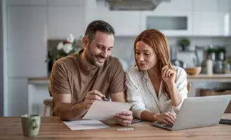 Loving couple working together on documents at their home office desk