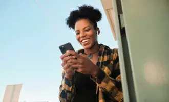 Mid adult woman laughing during video chat in smart phone