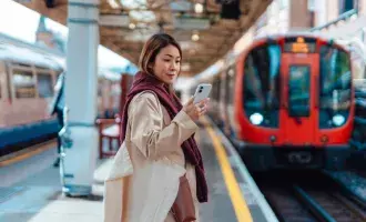 young-asian-woman-using-smartphone-while-waiting-for-train
