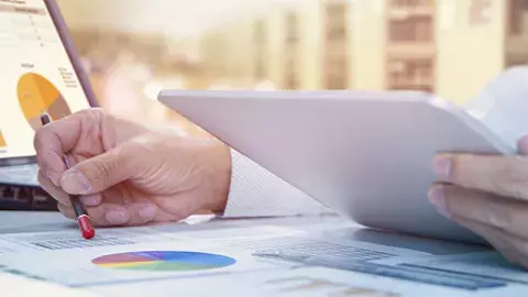 Capita Data & analytics Man looking at graph while holding a tablet