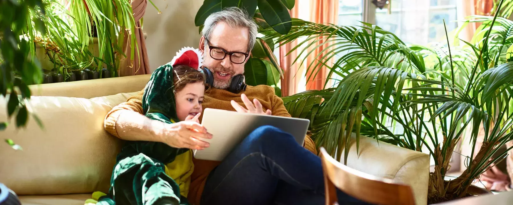 Grandfather playing game on laptop with granddaughter - 1800x720 GettyImages-1166771651