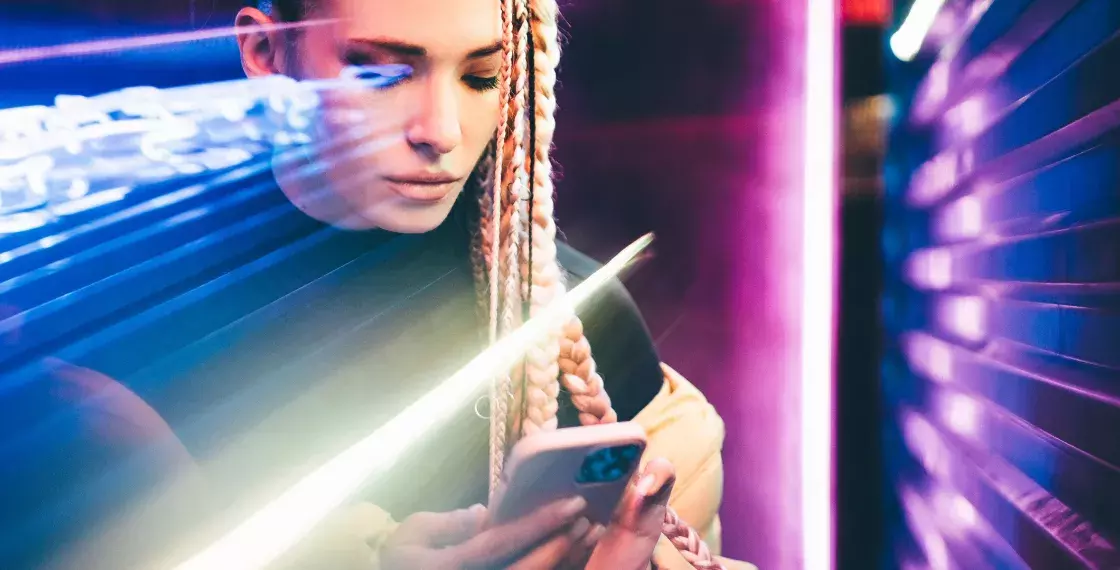 Woman using mobile phone in neon lights