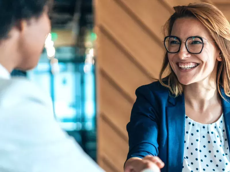 Female manager discussing and shaking hands in the office.